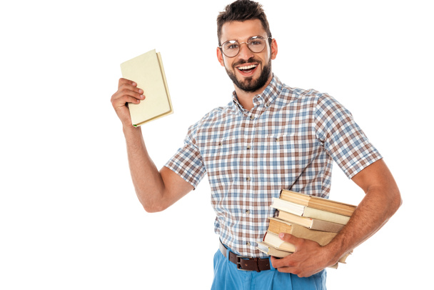 Cheerful nerd in eyeglasses holding books isolated on white - Foto, immagini