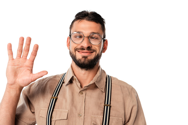 Lächelnder Strabismus-Nerd mit Brille, winkende Hand auf weißem Hintergrund - Foto, Bild