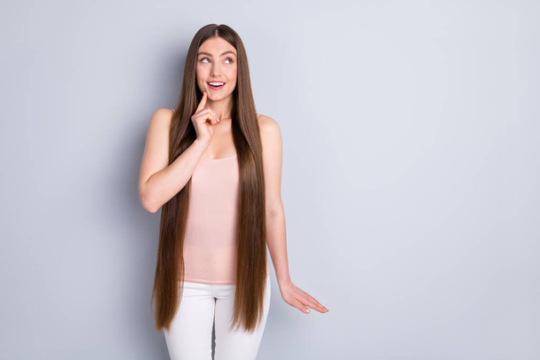 Photo of charming perfect appearance model lady demonstrating ideal neat long hairstyle looking interested side empty space wear singlet trousers isolated grey color background - Foto, imagen