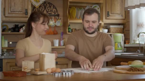 Married couple rolls the dough at the table. Happy family life. - Footage, Video