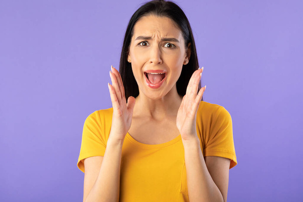 Молодая женщина, кричащая в фиолетовой студии
 - Фото, изображение