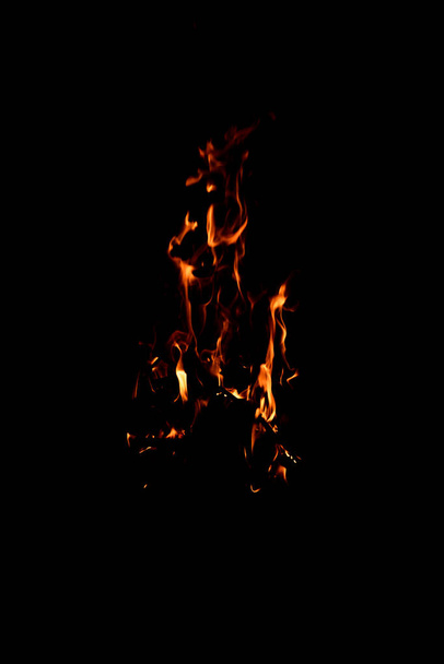 Bright firelight on a black background. The fire on a long exposure. Sparks and flames. - Photo, Image