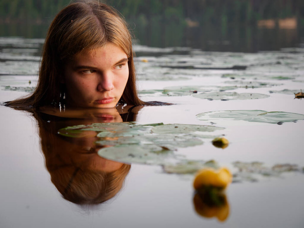 γοργόνα κορίτσι στο νερό μεταξύ νούφαρα στο ηλιοβασίλεμα 2020 - Φωτογραφία, εικόνα