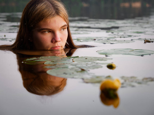 sellő lány a vízben között víz liliomok naplementekor 2020 - Fotó, kép