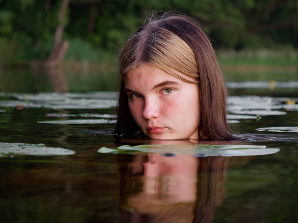 dziewczyna syrena w wodzie wśród lilii wodnych o zachodzie słońca 2020 - Zdjęcie, obraz
