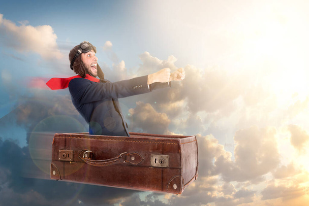 Homme d'affaires volant une vieille valise au-dessus du ciel - Photo, image