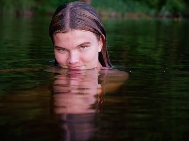 zeemeermin meisje in het water onder water lelies bij zonsondergang 2020 - Foto, afbeelding