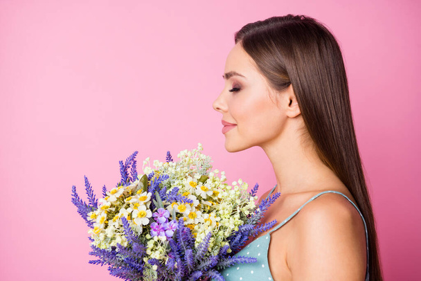 Close-up profile side view portrait of her she nice attractive lovely cute sweet charming fascinating dreamy girl holding in hands smelling flowers isolated over pink pastel color background - Valokuva, kuva