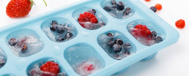 Fresh and frozen summer berries, strawberries, raspberries, blueberries, cherries on a white background - Zdjęcie, obraz