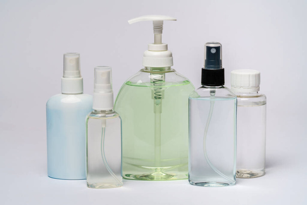 group of hand sanitizer spray or liquid soap bottles over light grey background - 写真・画像
