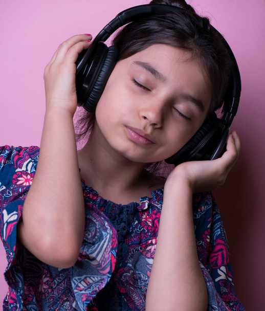 Fun young child enjoying rhythms in listening to music on headphones.  Catch the rhythm. Kid listening music headphones. Entertainment and fun. enjoy summer playlist. my favorite song. childrens day.  - Photo, Image