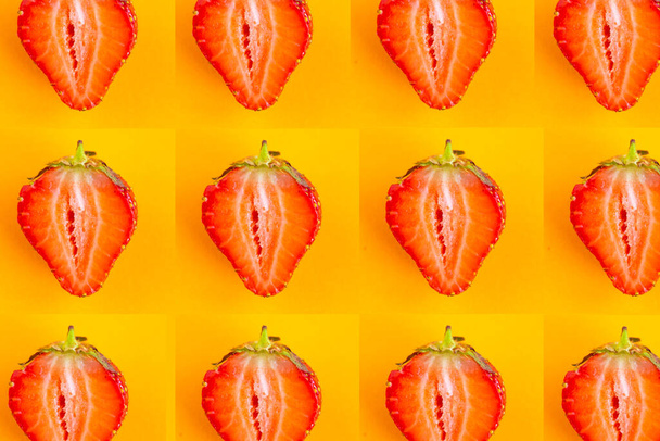 Sliced strawberry pattern on bright orange background, top view - Φωτογραφία, εικόνα