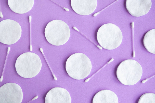 Esponjas de algodón y patrón de brotes de algodón sobre fondo púrpura, concepto mínimo
 - Foto, imagen