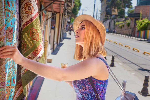 Belle voyageuse regarde tapis et tapis turcs traditionnels à Istanbul, Turquie.Style de vie de la femme voyageuse Concept. - Photo, image