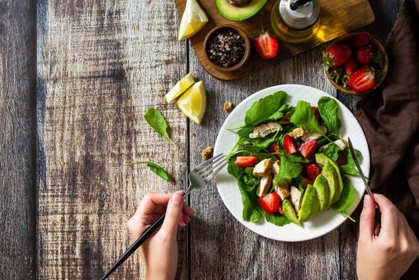 Lunch for keto. Summer salad with strawberries, grilled chicken and avocado on a rustic table. Top view flat lay background. Copy space. - Photo, Image