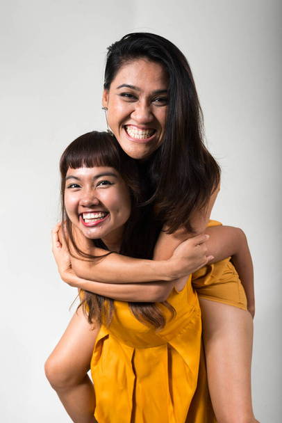 Studio shot of two young Asian women together against white background - Foto, Imagen