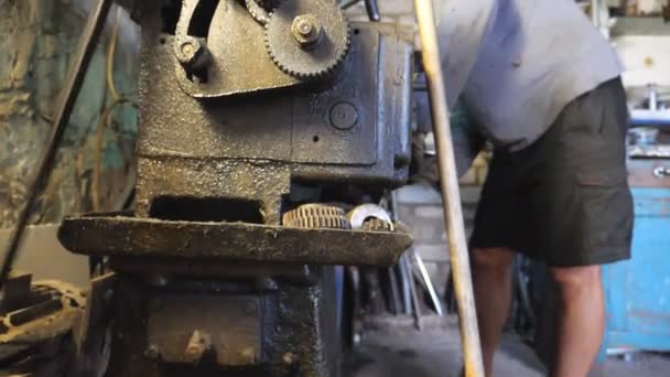 Adult man working with workbench in his garage or workshop. Mechanic or turner using lathe for metal processing. View on turning work. Slow motion - Footage, Video