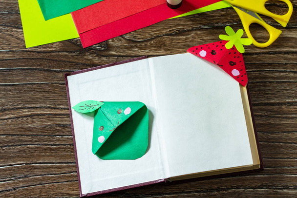 Origami da un segnalibro di carta per libri una fragola e una mela su un tavolo di legno. Progetto artistico per bambini, fatto a mano, artigianato per bambini. - Foto, immagini