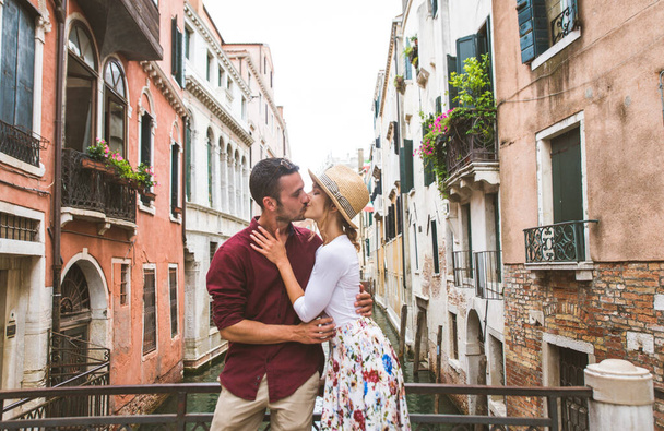 Beatiful young couple having fun while visiting Venice - Tourists travelling in Italy and sightseeing the most relevant landmarks of Venezia - Concepts about lifestyle, travel, tourism - Фото, изображение