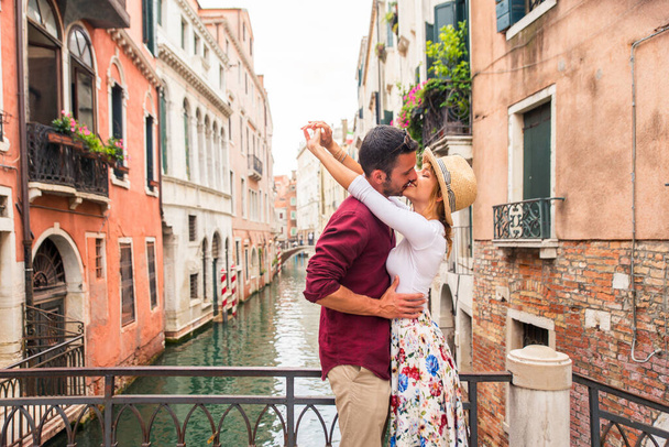 Beatiful young couple having fun while visiting Venice - Tourists travelling in Italy and sightseeing the most relevant landmarks of Venezia - Concepts about lifestyle, travel, tourism - Photo, image