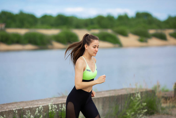 Pretty athletic woman in stylish sportswear running in nature, photography for blog or ad of sport and healthy lifestyle - Fotoğraf, Görsel