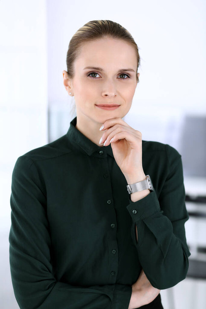 Business woman headshot in modern office. Secretary or female lawyer standing straight and looking at camera. Business people concept - Fotó, kép