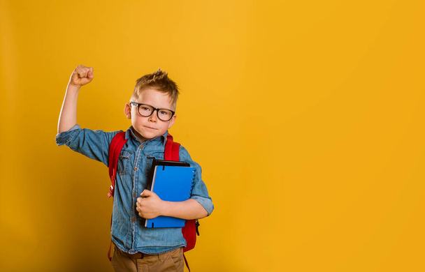 childhood, power, strength and people concept - happy smiling boy in green polo t-shirt showing strong fists over green school chalk board background - Fotografie, Obrázek