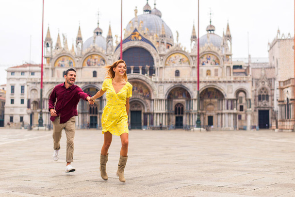 Beatiful young couple having fun while visiting Venice - Tourists travelling in Italy and sightseeing the most relevant landmarks of Venezia - Concepts about lifestyle, travel, tourism - Foto, imagen