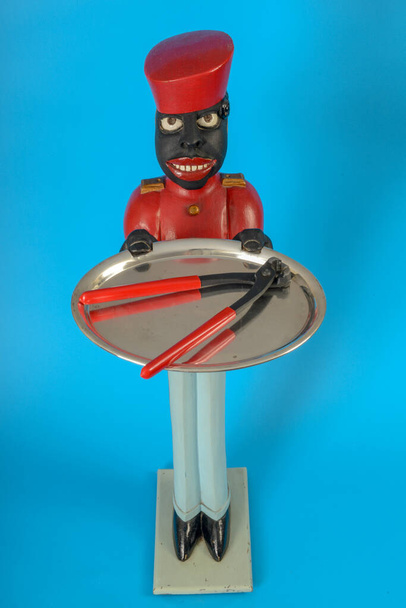 Standbeeld van een zwarte dienaar met een tang op een dienblad - Foto, afbeelding