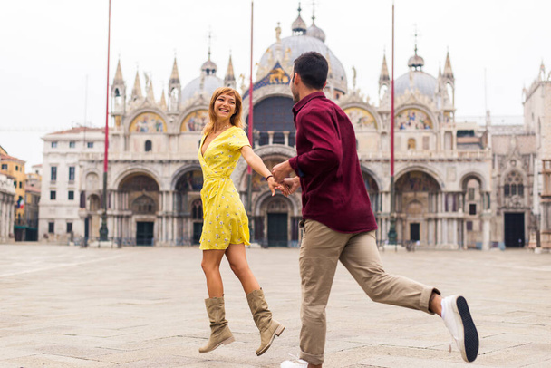 Beatiful young couple having fun while visiting Venice - Tourists travelling in Italy and sightseeing the most relevant landmarks of Venezia - Concepts about lifestyle, travel, tourism - Zdjęcie, obraz