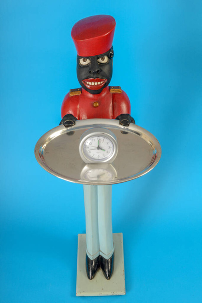 Estátua de um servo negro com um relógio em uma bandeja
 - Foto, Imagem