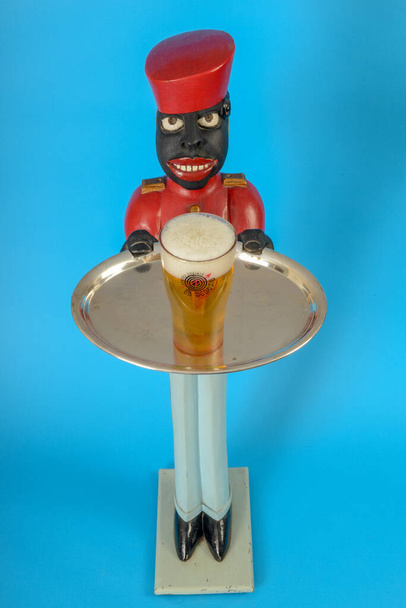 Egy fekete szolga szobra egy pohár sörrel a tálcán. - Fotó, kép