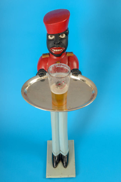 Statue eines schwarzen Dieners mit einem Glas Bier auf einem Tablett - Foto, Bild