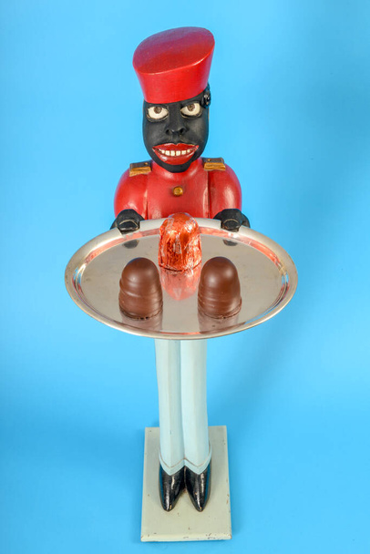 Statue eines schwarzen Dieners mit Schokoladenkuchen auf einem Tablett - Foto, Bild