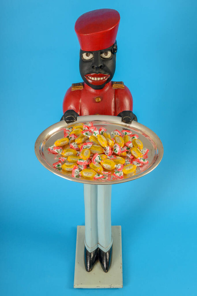 Estátua de um servo preto com doces em uma bandeja
 - Foto, Imagem