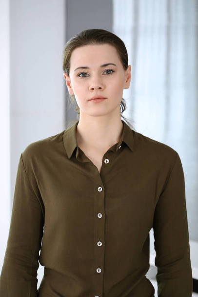 Business woman standing and looking at camera in office. Headshot of casual dressed girl - Foto, afbeelding