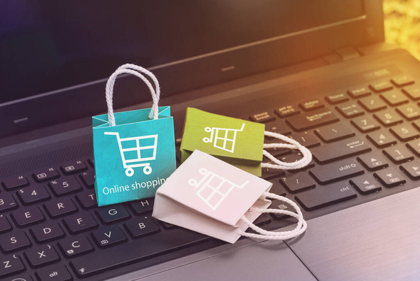 Online shopping on website, paper shopping bags on notebook keyboard. business concept about online shopping or order goods on the internet It is more popular. can buy everything from home or office. - Photo, Image
