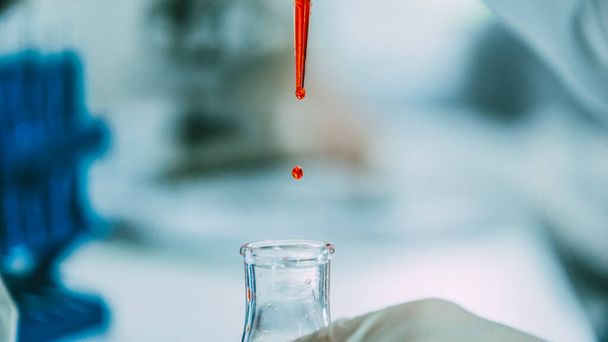 close up. background image of a drop of red liquid in a laboratory pipette. - Zdjęcie, obraz