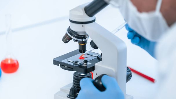 close up. scientist using a microscope to study blood . - Φωτογραφία, εικόνα