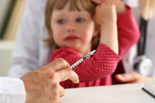 Liitle niño asustado mirando al médico antes de la vacunación
 - Foto, imagen