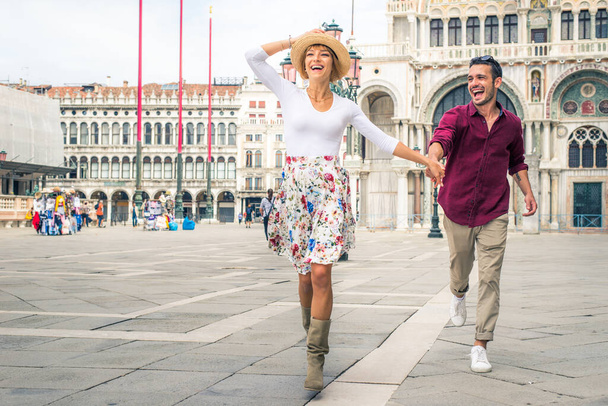 Beatiful young couple having fun while visiting Venice - Tourists travelling in Italy and sightseeing the most relevant landmarks of Venezia - Concepts about lifestyle, travel, tourism - Foto, imagen