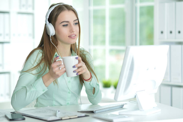 Portrait of  businesswoman working in headphones  in office - Foto, Imagen
