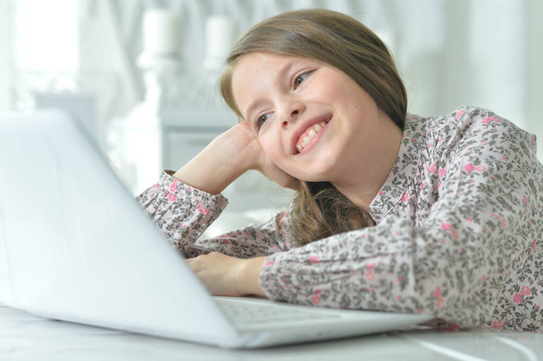 ragazza felice utilizzando il computer portatile a casa - Foto, immagini