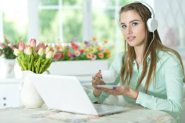 Portrait of  businesswoman in headphones working in office with laptop - 写真・画像