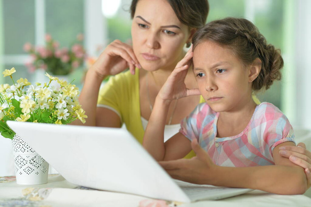 portrait of  sad   mother and daughter using laptop - Photo, Image