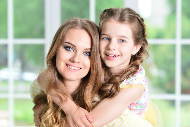 Close-up portrait of a charming little girl with mom at home - Foto, Imagem