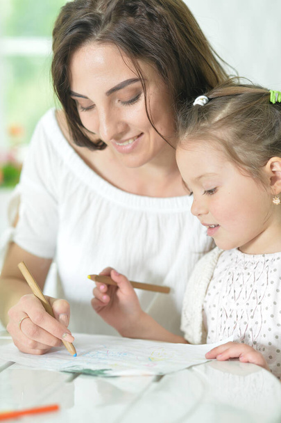 cute girl with mother drawing at the table - Foto, Imagen