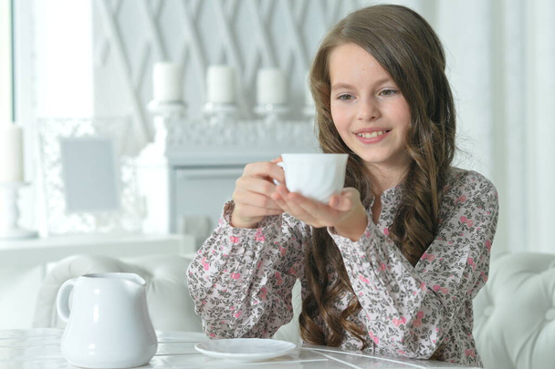Cute girl drinking tea at light kitchen - Zdjęcie, obraz