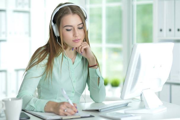 Portrait of  businesswoman working in headphones  in office - Photo, Image