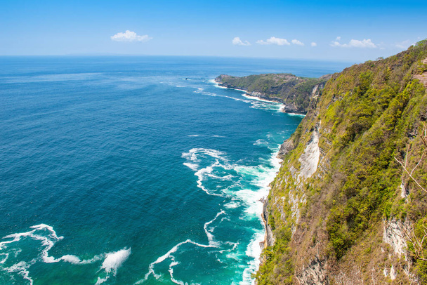 A horizon landscape of Kelingking beach sea shore green-aqua water wave from the top during the touristic visit in Nusa penida, Indonesia - Photo, Image